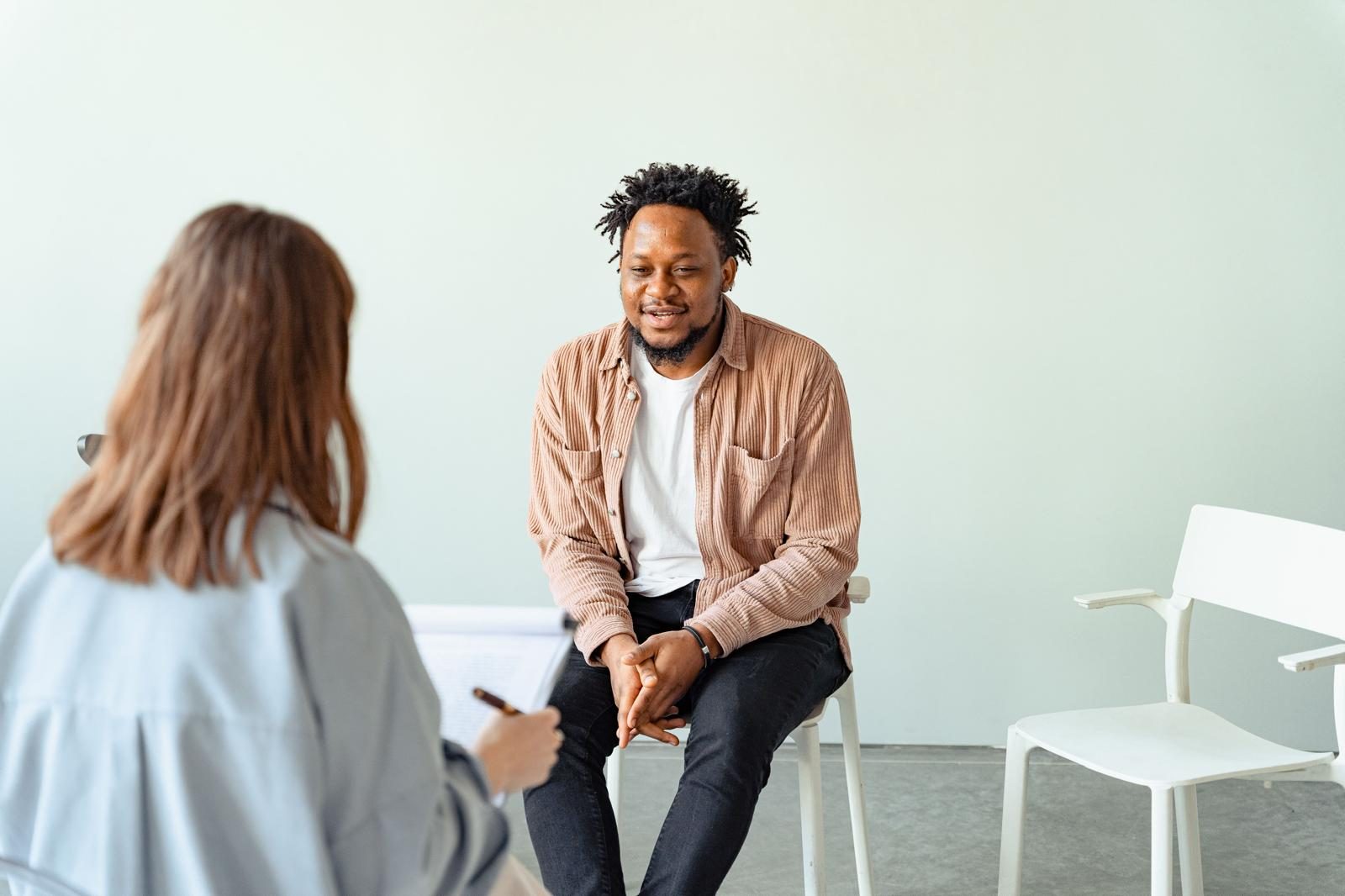 A man talking with a mediator taking notes during a calm one-to-one session
